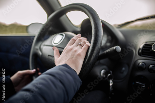 woman drives a car, holds the steering wheel on a trip.