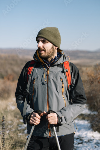 Portrait of a bearded hiker standing on field path