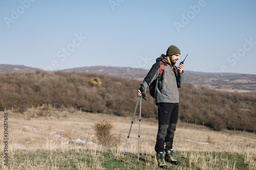 Man standing on a hill and talking on walkie-talkie