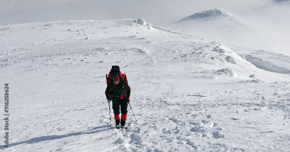 Hiker in the winter mountains on a sunny day Hiker in the winter mountains on a sunny day