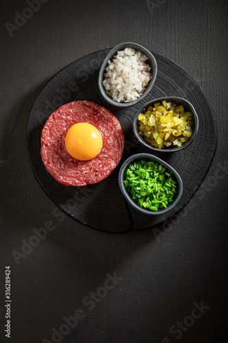 Tasty beef tartare with chives, gherkin and yolk