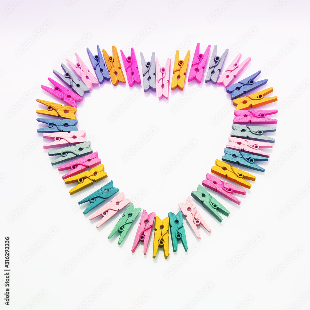 Composition for Valentine's Day. Big heart made of multicolor clothespins of hearts on a white background. Flat lay, copy space, top view, February 14th.