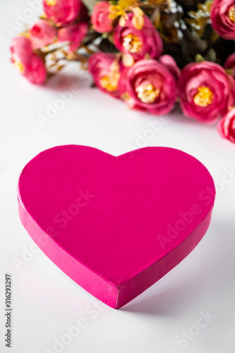Pink heart for valentines day on a background of flowers.