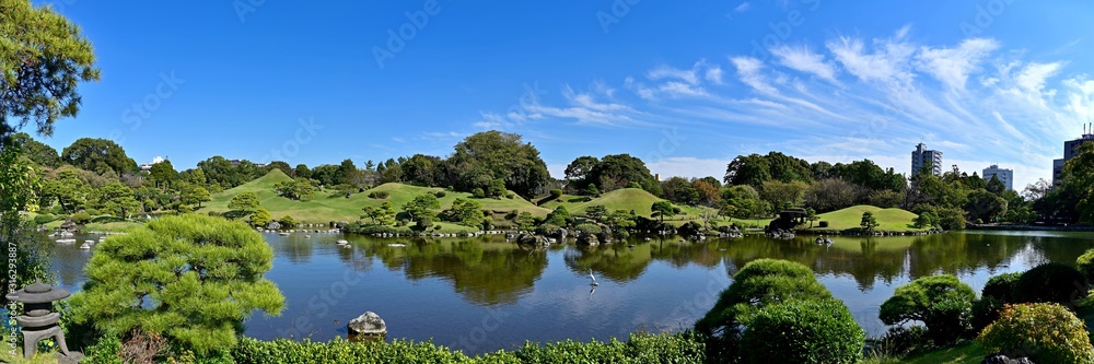 ビルに囲まれた街中の日本庭園のパノラマ情景