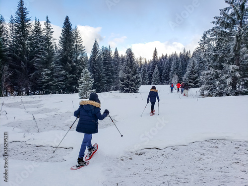 People snowshoeing on a trail in the French Alps. 