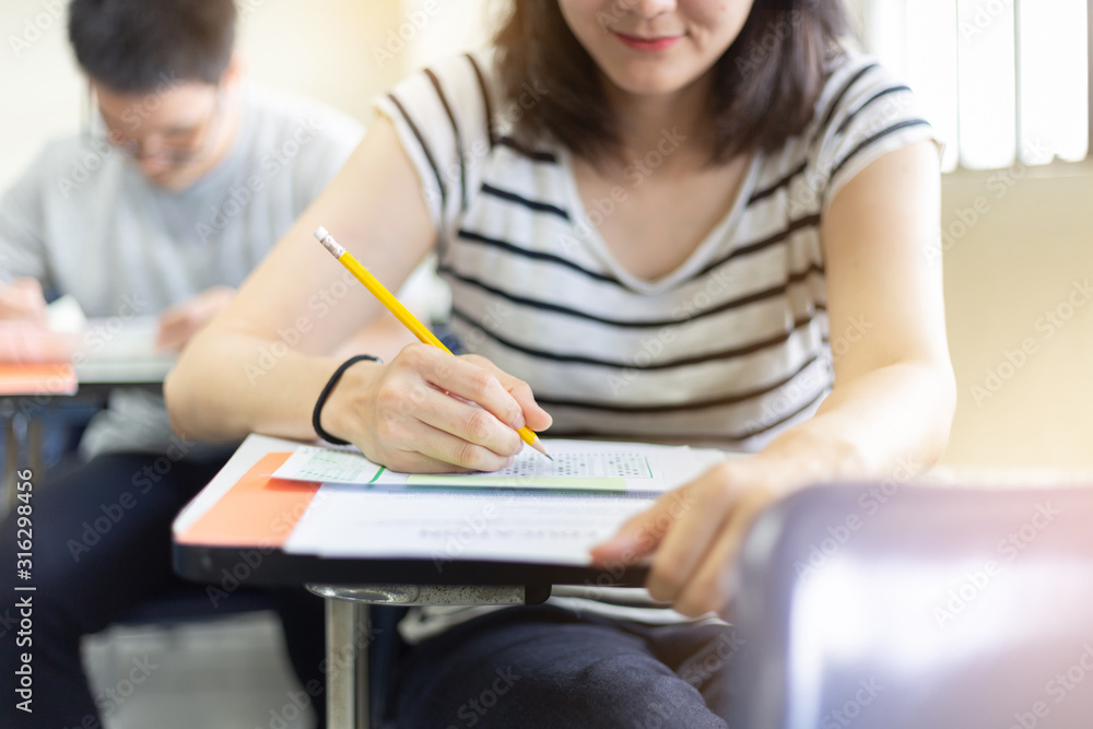 high school,university student study.hands holding pencil writing paper answer sheet.sitting lecture chair taking final exam attending in examination classroom.concept scholarship for education abroad high school,university student study.hands holding pencil writing paper answer sheet.sitting lecture chair taking final exam attending in examination classroom.concept scholarship for education abroad