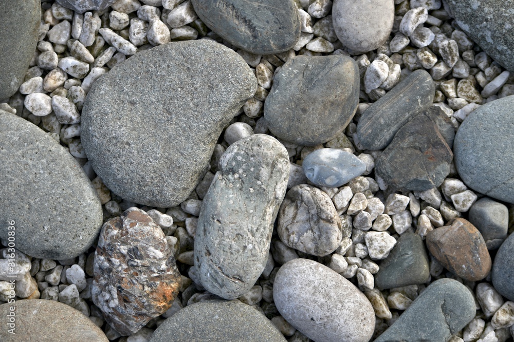 A stone horizontal background of sea pebbles and light rubble. A stone horizontal background of sea pebbles and light rubble.