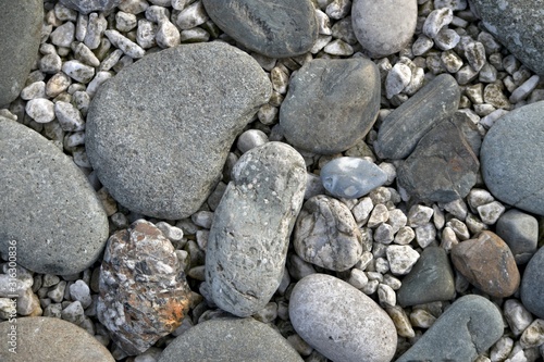 A stone horizontal background of sea pebbles and light rubble.