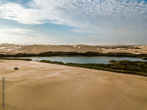 Fototapeta Naklejka Na Ścianę i Meble -  Aerial view of car in the desert and lake of peru