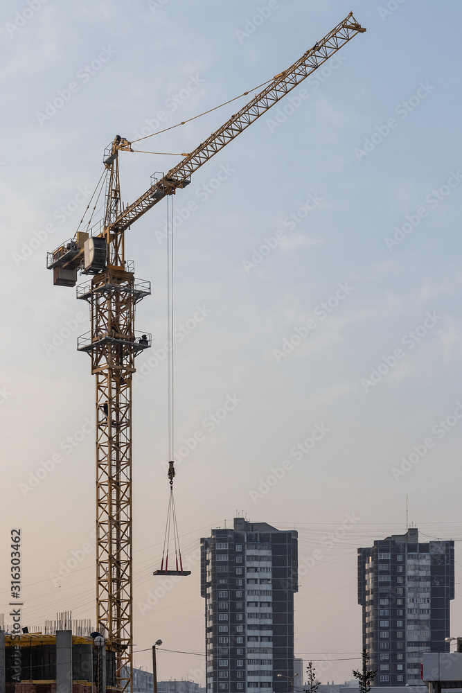 New residential area: high-rise construction crane against the s