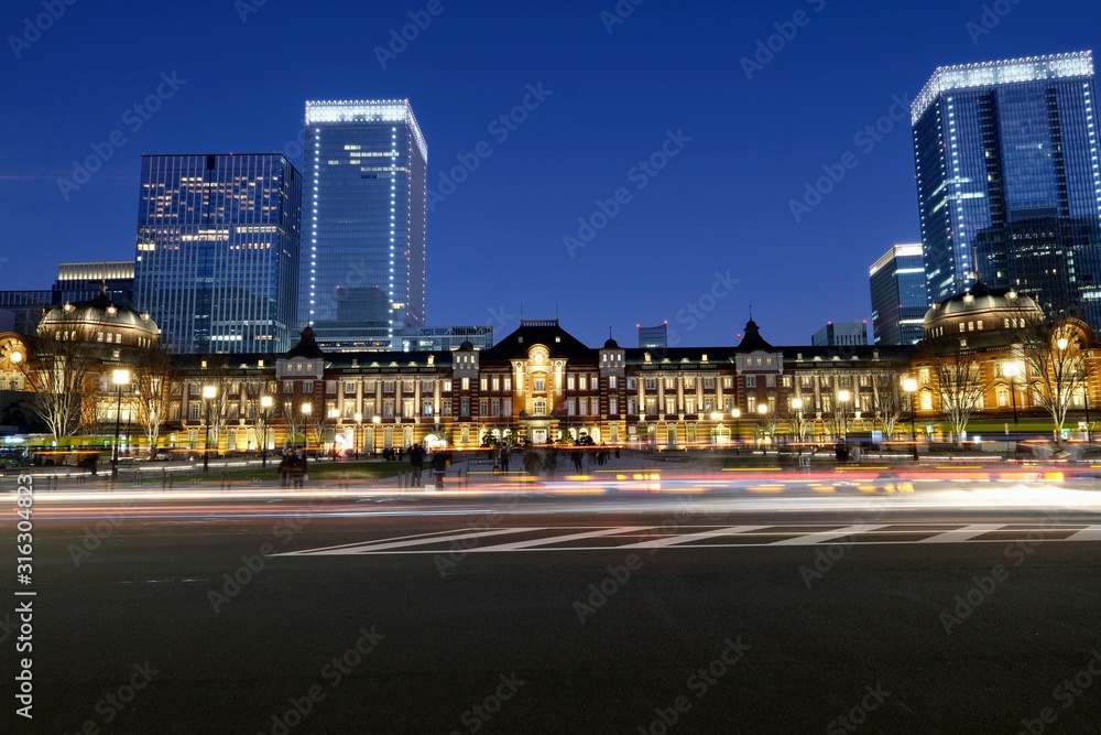 cars passing by famous railway station in Tokyo at night. long exposure and wide angle