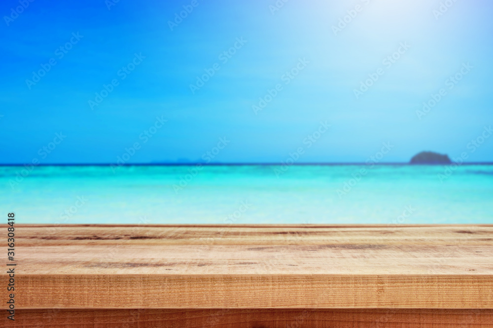 Blurred nature summer tropical beach background and wooden table.