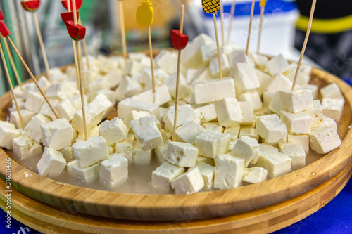 Diced fetax cheese. Pile in a wooden plate. photo