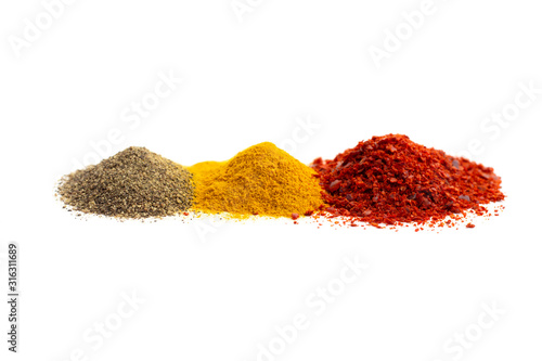 Ground red and black pepper and turmeric isolated on white background, front view.