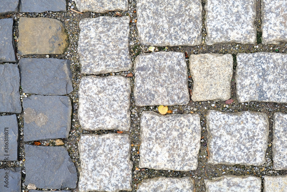 Fototapeta premium Texture of old Cobbled Pavement close-up. Granite Stone Background..