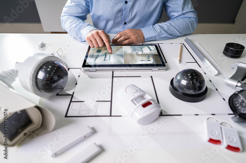 Person Holding Digital Tablet With CCTV Camera Footage On Screen