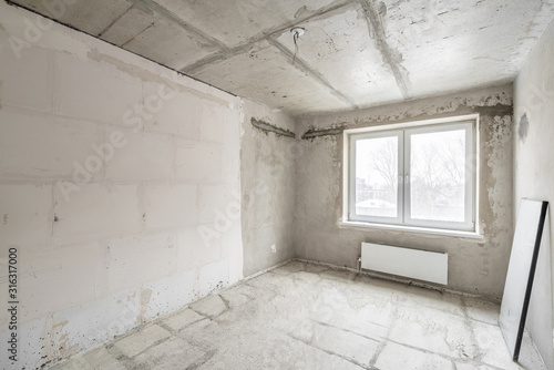 Empty interior for design, gray concrete wall. Empty room. Space for text and picture. Concrete walls, slabs, interior of a new residential building. Partitions in a new apartment.