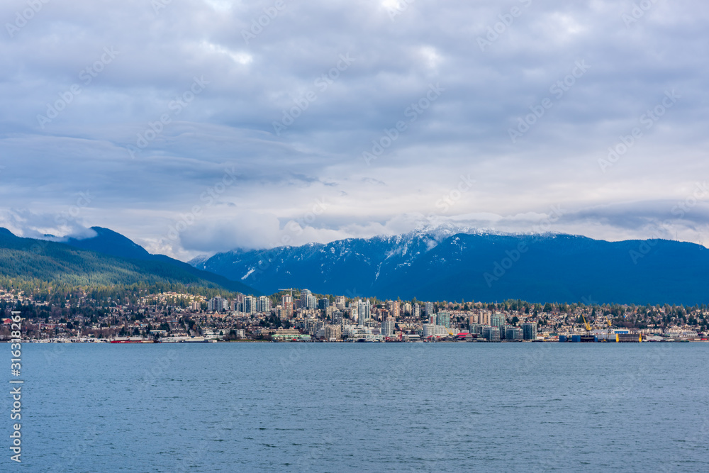 View on Vancouver Downtown and Mountains over ocean. British Columbia. Canada.