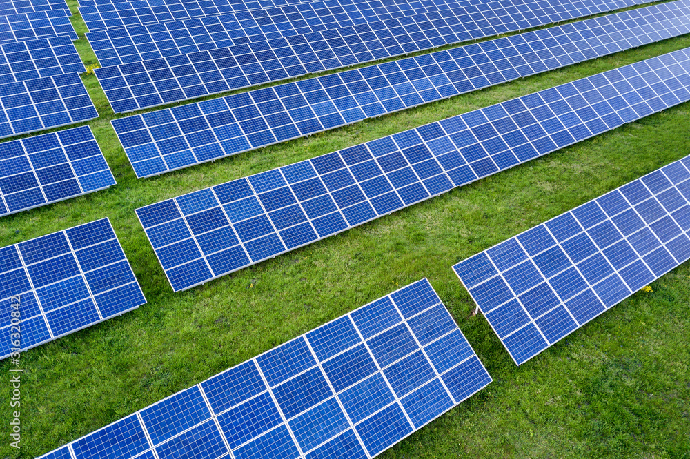 Surface of solar photo voltaic panels system producing renewable clean energy on green grass background. Surface of solar photo voltaic panels system producing renewable clean energy on green grass background.