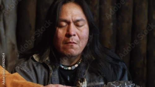 Native American Man in Prayer Meditation with Sage Smoke in Hogan