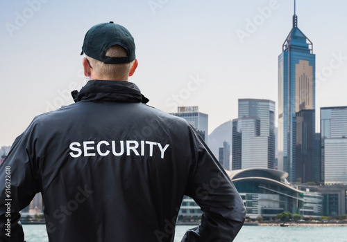 Male Security Guard Looking At City Skyline
