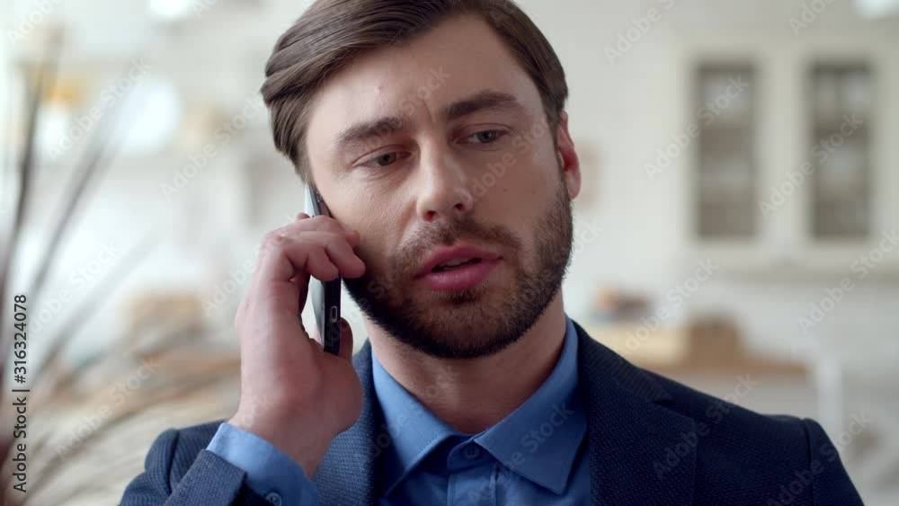 Attractive business man making phone call at home. Guy talking on cellphone Attractive business man making phone call at home. Guy talking on cellphone