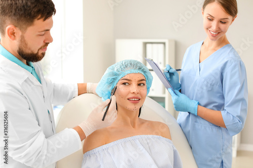 Plastic surgeon applying ma...