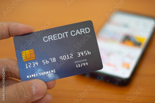 Hands holding plastic credit card and using Mobile Phone for online shopping. Online shopping concept