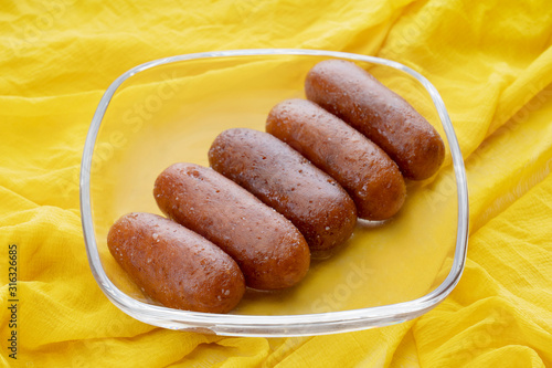 Langchas kept in a glass bowl on a yellow cloth. 	 photo