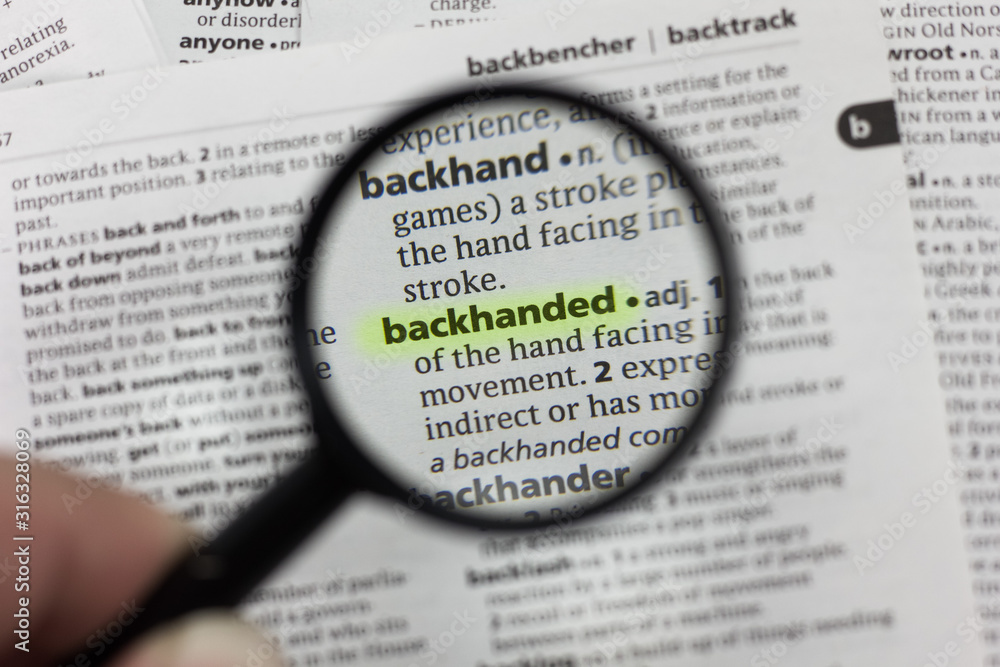 The word or phrase backhanded in a dictionary. The word or phrase backhanded in a dictionary.