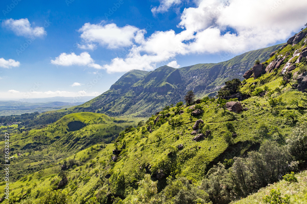 Panoramic view over steep and green mountains, sunny day, Drakensberg, Giants Castle Game Reserve, South Africa Panoramic view over steep and green mountains, sunny day, Drakensberg, Giants Castle Game Reserve, South Africa
