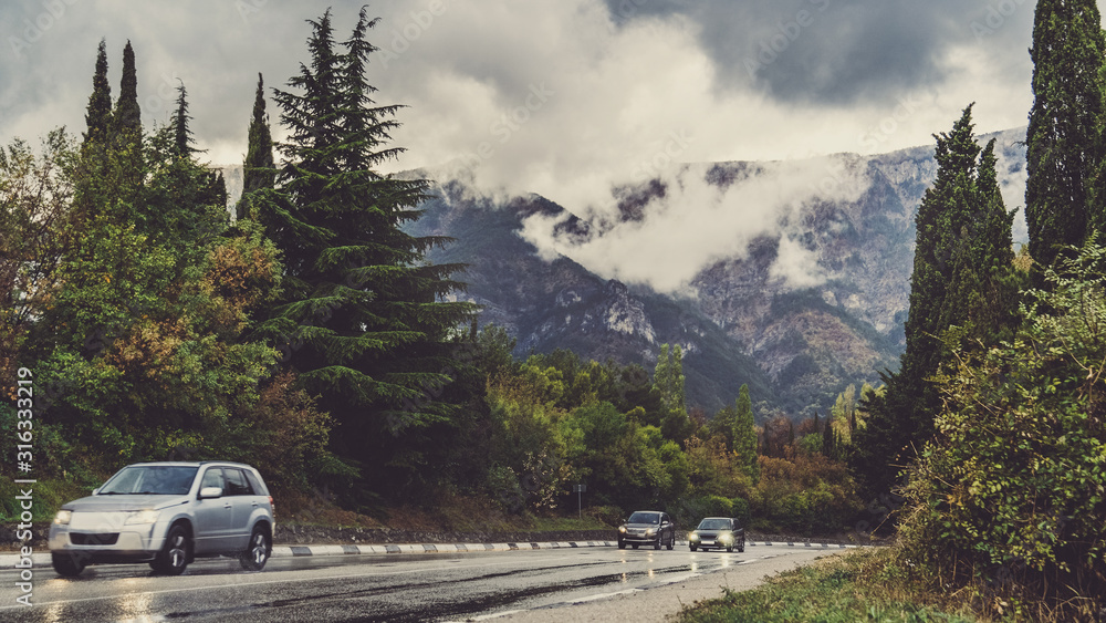 Highway in the mountains. Cumulus clouds and mountain landscape in rainy weather. Crimea in autumn. View from the car window. Highway in the mountains. Cumulus clouds and mountain landscape in rainy weather. Crimea in autumn. View from the car window.