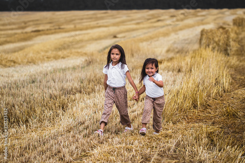 Little girl running across the sunny field.