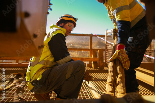 Defocused rigger wearing fall safety helmet clear glass friend hand wearing safety final safety check of three tone crane lifting sling inspection before commencing task construction site Australia   