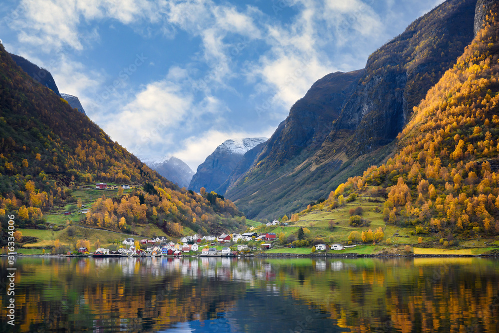 The village of Undredal is a small village on the fjord. Aurlandsfjord West coast of Norway, High mountains and villages reflect in the water during autumn season.