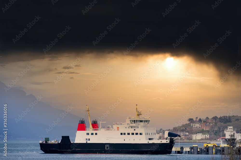 Ship ferry landing arrival at dock port under black storm clouds in the sky Wemyss Bay Scotland