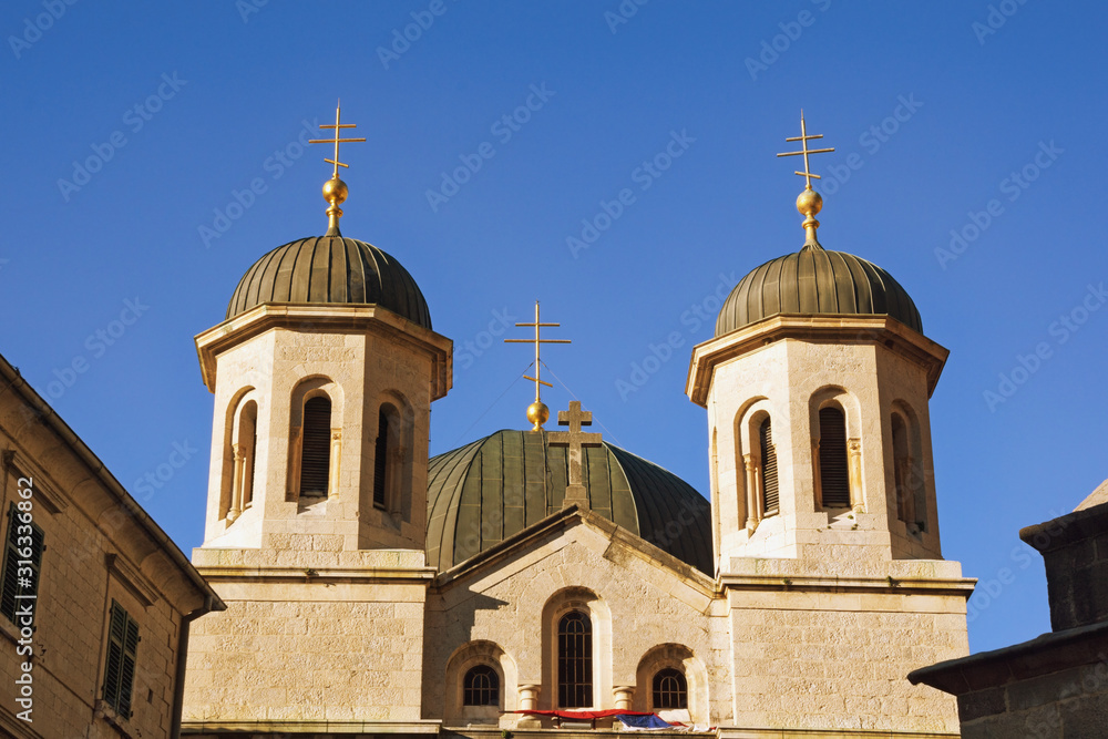 Religious architecture. Montenegro, Old Town of Kotor. Domes of Orthodox Church of St. Nicholas against blue sky
