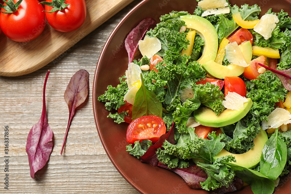 Tasty fresh kale salad on wooden table, flat lay Tasty fresh kale salad on wooden table, flat lay