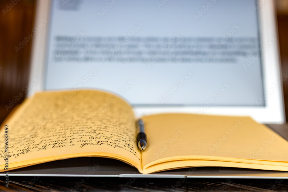 Obraz premium Blogger concept. There is a pc laptop with notebook and pen at a table in a cafe. selective focus