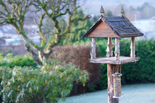 Bird house and nut food feeder holder wooden in home garden during winter