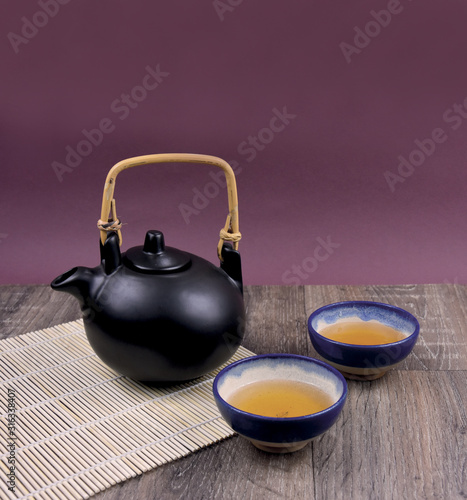 Traditional Chinese tea on the table stock images. Ceramic brown tea set stock images. Traditional chinese tea set frame arrangement. Green tea on a wooden background with copy space for text