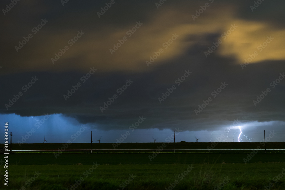 Storm with distant cloud to ground lightning strike at night