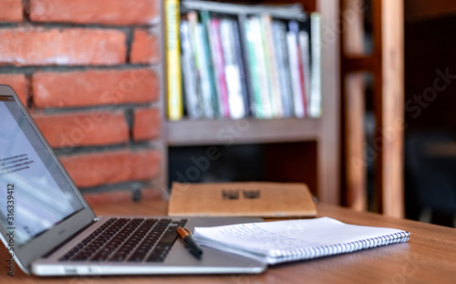 Blogger concept. There is a pc laptop with notebook and pen at a table in a cafe. selective focus