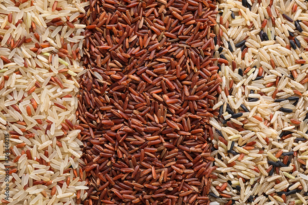 Different types of brown rice as background, top view