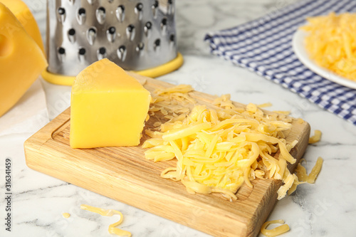 Delicious grated cheese on white marble table