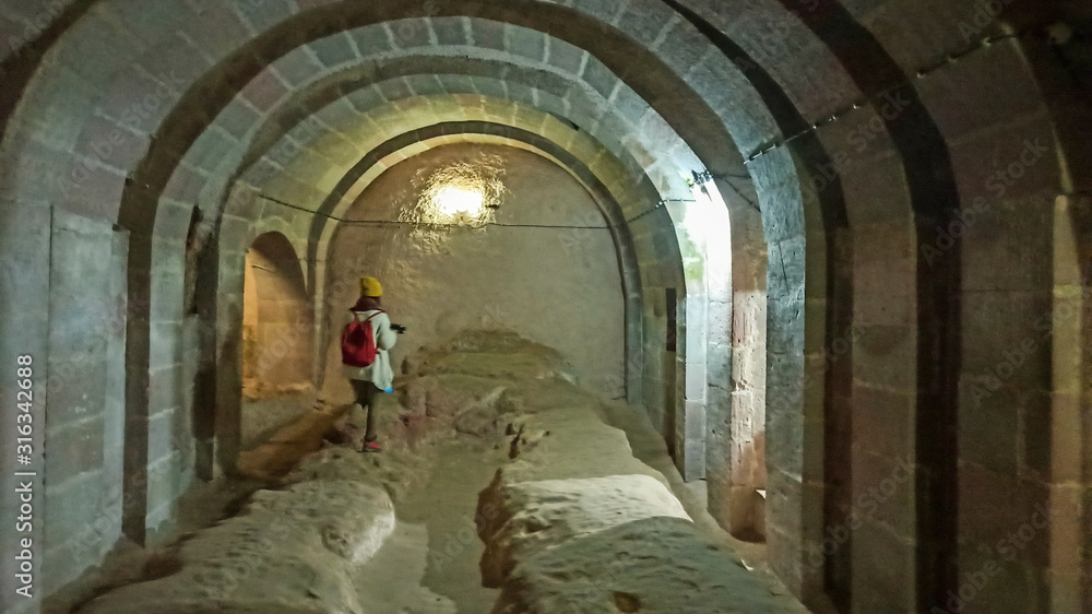 Woman alone in Ancient multi-level cave Derinkuyu Underground City in Cappadocia, Turkey