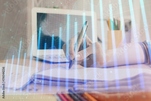 Financial forex charts displayed on woman's hand taking notes background. Concept of research. Double exposure