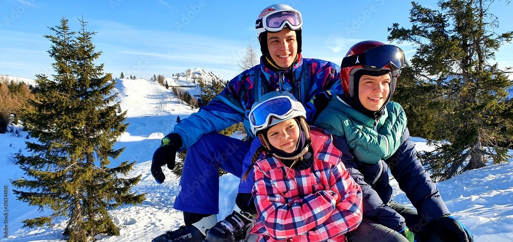 Dzieci rodzeństwo podczas ferii zimowych ww włoskich górach Dolomitach, dobrze sie bawia podczas ferii zimowych jeżdżąc na nartach - obrazy, fototapety, plakaty 