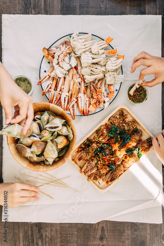 Top view of steamed Flower Crabs and Giant Mud Crabs with separated parts of steamed crab such as claw meat and body with grilled Laevistrombus Canarium in the shell. photo