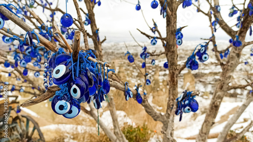 Blue Evil eye charms hang on the tree in Cappadocia, Turkey
